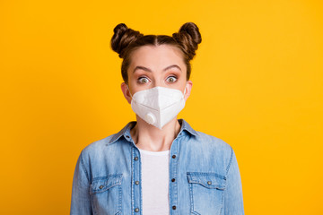 Closeup photo of attractive amazed young lady two buns outdoors use safety medical facial respirator quarantine big eyes see people wear casual denim shirt isolated yellow color background