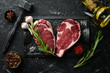 © Yaruniv-Studio - Two raw beef steak ribeye on a stone table. Top view. Free space for your text.