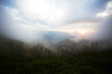 Colorful autumn scenery with bright trees, mountain view and clouds