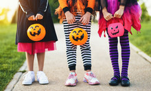Happy Halloween! Legs Of Funny Children In Carnival Costumes Outdoors