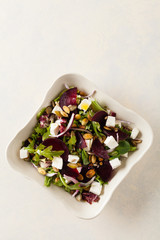 Wall Mural - Vegetarian salad with beets and feta. Served in a square bowl. Top view.