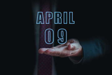 april 9th. Day 9 of month, announcement of date of  business meeting or event. businessman holds the name of the month and day on his hand.. spring month, day of the year concept