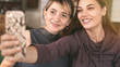 © sebra - Two young women taking a selfie with mobile phone at home