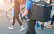 © Tricky Shark - Food delivery man walking among crowd of people. Delivery boy with protective gloves walking down the street, restaurants delivery service. Man walking with thermal bag, grocery delivery