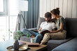© Drobot Dean - Lovely young couple relaxing on a couch at home, reading magazine