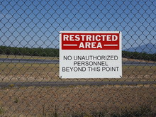 Authorized personnel sign on an airport fence
