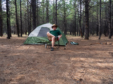 A Man Resting After Setting Up Camp In The Forest