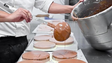 Wall Mural - Pastry Chef making fresh delicious chocolate cakes at commercial kitchen. High quality FullHD footage