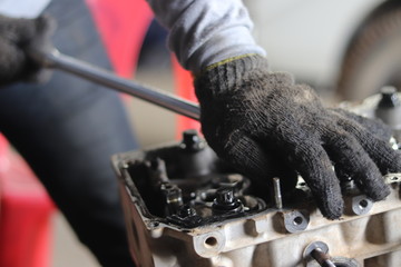 The mechanic is checking the engine.