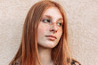 Close-up portrait of young teen freckled ginger girl looking away