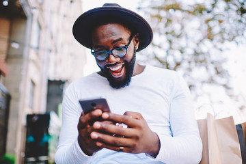 emotional surprised african american guy with low prices in web store receiving message with promo c