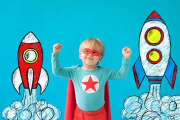 Wall Mural - Portrait of superhero child against blue background