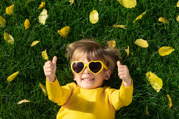 Canvas Print - Happy child having fun outdoor in autumn park