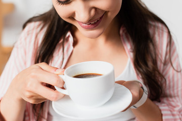  cropped view of young woman holding cup of coffee