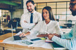 © BullRun - Young crew of financial managers discussing solutions checking accountings via application on laptop, colleagues collaborating browsing website with information on netbook share ideas during meeting