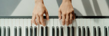 Woman Learning To Play Piano At Home On Digital Keyboard. Panoramic Banner Crop Of Hands Playing Beginner Chords To Learn Playing By Herself.