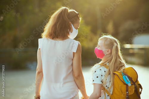 Fotomural young mother and child coming back from school outside