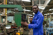 © godji10 - Portrait of smiling african american factory worker showing thumb up. Technician engineer control machines in the workplace on a business day. Concept of Industrial manufacturing.