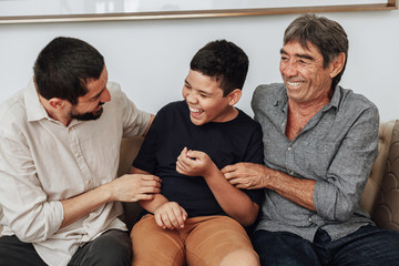 Wall Mural - Male members of three generation family enjoying the day together in home