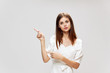 © SHOTPRIME STUDIO - Woman with long hair gestures with her hands pointing to the top of a white dress Copy Space