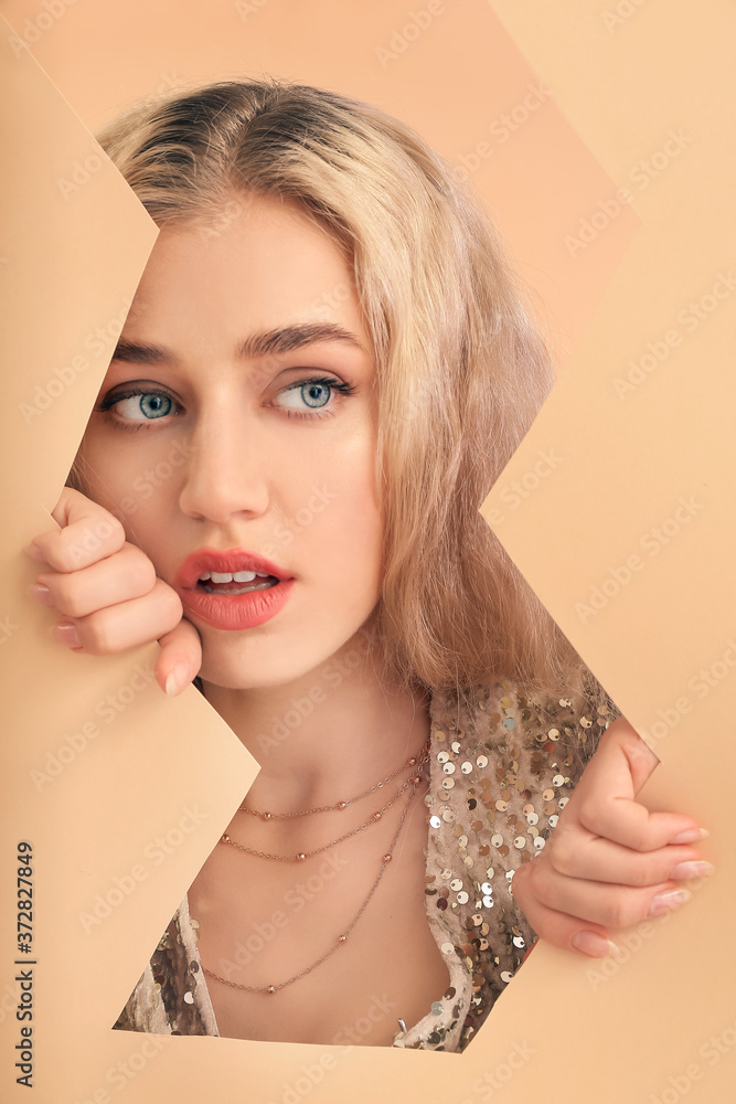 Young woman with beautiful makeup and paper sheets on color background