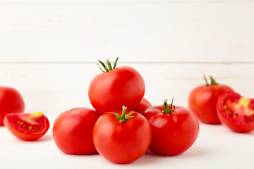 Ripe red tomatoes on a white wooden background