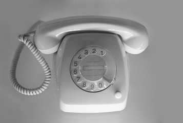 Vintage gray telephone with rotary dial isolated on white background