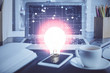 © peshkova - Computer on desktop in office with bulb icon hologram. Double exposure. Concept of idea.