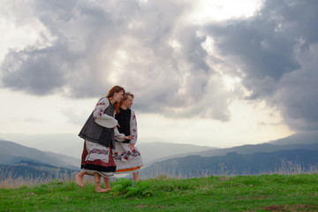 two emotional cheerful girl in Ukrainian embroidery clothes