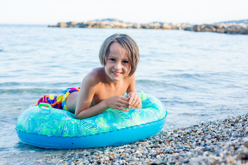 Sweet child, boy, lying on the beach in France on sunset