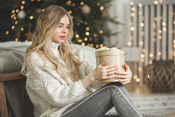 Wall Mural - Closeup portrait of attractive blond young woman on christmas background