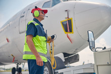 Man In Headset Standing By A Pushback Tractor