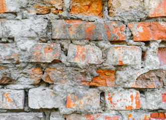 Wall Mural - The texture of an old wall of red, orange uneven bricks with gray cement and concrete. Photography, abstraction, background.