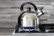 a metal teapot boils on the gas stove close up