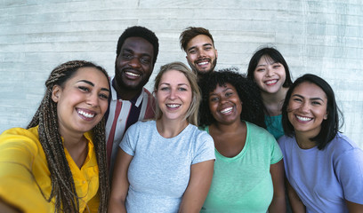 group multiracial friends having fun outdoor - happy mixed race people taking selfie together - yout