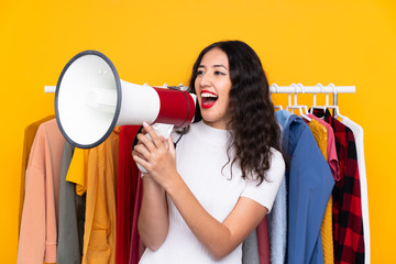 Wall Mural - Mixed race woman in a clothing store and holding a megaphone