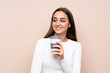 © luismolinero - Young woman over isolated background holding coffee to take away
