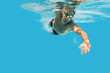 Pro male swimmer in the swimming pool. Underwater swim photo with copy space.