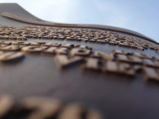 Wall Mural - Low angle shot of a text on a smooth surface on a blue sky background