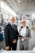 © JustLife - Man and woman discussing work. Colleagues working in factory..