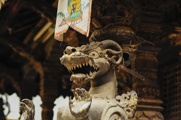 Wall Mural - Low angle shot of a stone dragon statue inside an Asian building