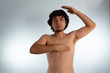 © Antonio Tanaka - Young naked hispanic man with wavy hair and shaved beard, doing a checkup on his chest for signs of breast cancer