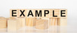 word example written on wooden cubes and white background