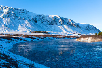 Wall Mural - Iceland's breathtaking winter landscapes. River with pieces of ice on the background of mountains