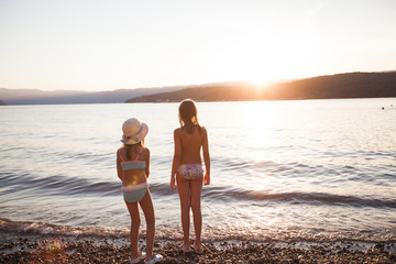 Wall Mural - Children have fun on the beach at sunset