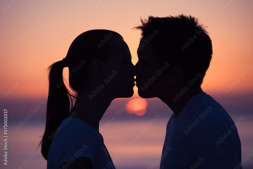 silhouette of a couple kissing at sunset Stock Photo | Adobe Stock