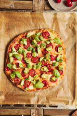 Sticker - Vertical closeup shot of a pizza with vegetables on wooden table