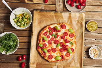 Sticker - Closeup shot of a pizza with vegetables on wooden table