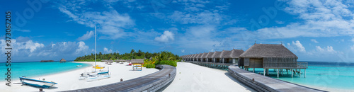 Panorama landscape of the tropical beach with over water bungalows and alms tree Poster Mural XXL