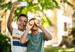© Sanja - Two boys are taking pictures with a mobile phone, one put a lemons on his eyes